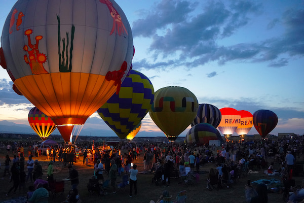 As the sun sets over Erie, Colorado, the hot air balloons light up the sky