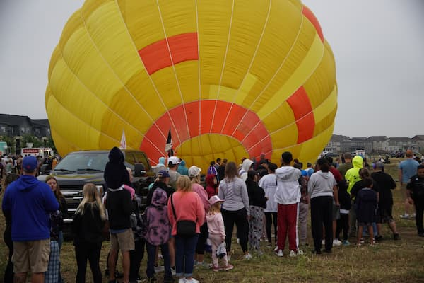 Spectators walk through a retired balloon on its side at the festival.