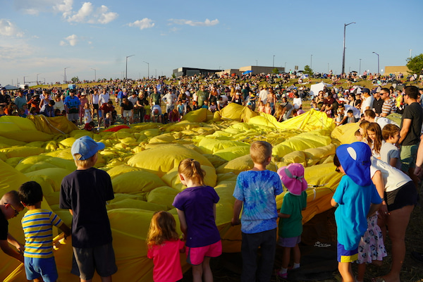 Kids playing in the fabric of a hot air balloon at the glow